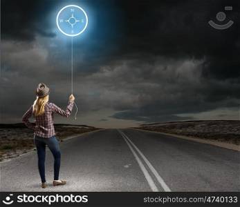 Travel concept. Rear view of young woman with balloon in hand