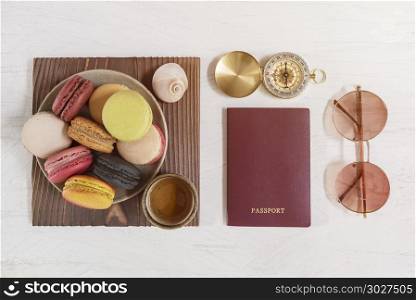 Travel concept, red passport on white table with compass, sungla. Travel concept, red passport on white table with compass, sunglasses and macaroons with tea cup.