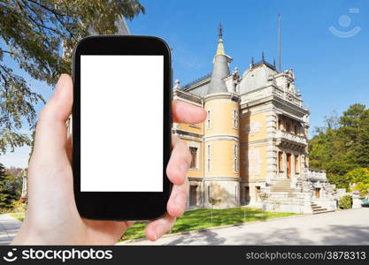 travel concept - tourist photograph Masandra Palace of Emperor Alexander III in Crimea on smartphone with cut out screen with blank place for advertising logo