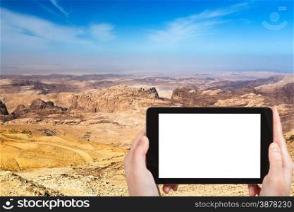 travel concept - tourist photograph mountain landscape of Jordan near Petra on tablet pc with cut out screen with blank place for advertising logo