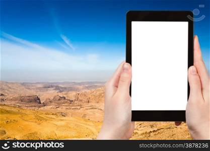travel concept - tourist photograph mountain panorama of Jordan near Petra on tablet pc with cut out screen with blank place for advertising logo