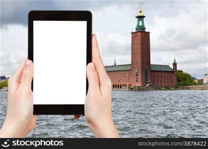 travel concept - tourist photograph Stockholm City Hall, Sweden on tablet pc with cut out screen with blank place for advertising logo