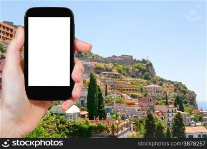 travel concept - tourist photograph Taormina resort city from Castelmola town, Sicily, Italy on tablet pc with cut out screen with blank place for advertising logo