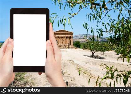 travel concept - tourist photograph Temple on Concordia in Valley of Temples and town Agrigento, Sicily, Italy on tablet pc with cut out screen with blank place for advertising logo
