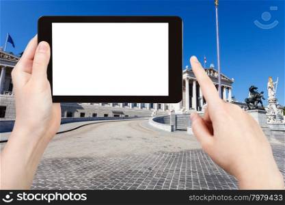 travel concept - tourist photographs Austrian Parliament Building in Vienna on tablet pc with cut out screen with blank place for advertising logo