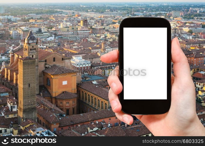 travel concept - tourist photographs Bologna skyline on smartphone with cut out screen with blank place for advertising in Italy