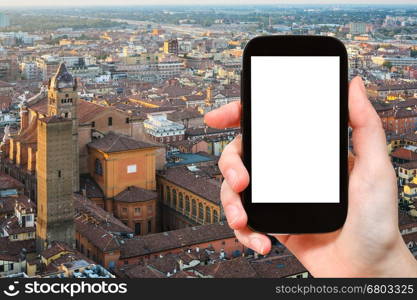 travel concept - tourist photographs Bologna skyline on smartphone with cut out screen with blank place for advertising in Italy