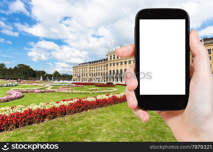 travel concept - tourist photographs of garden in Schloss Schonbrunn palace in Vienna on smatphone with cut out screen with blank place for advertising logo