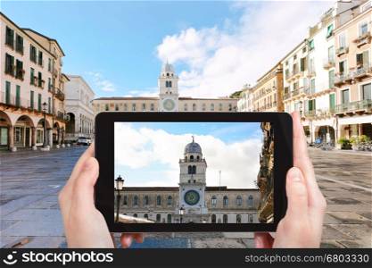 travel concept - tourist photographs palace Capitanio and Camerlenghi on piazza dei Signori in Padua city on tablet in Italy