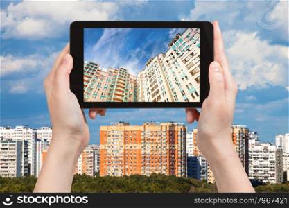 travel concept - tourist photographs picture of apartment houses on tablet pc