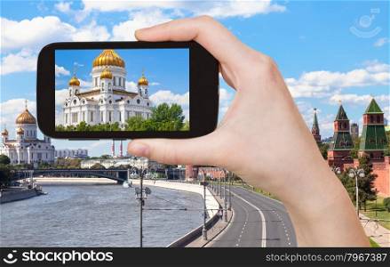 travel concept - tourist photographs picture of Cathedral of Christ the Saviour, Moscow on smartphone