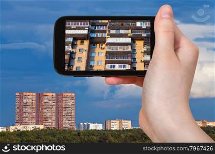 travel concept - tourist photographs picture of facade of modern house on smartphone