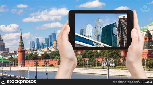 travel concept - tourist photographs picture of Moscow City on tablet pc