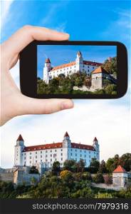 travel concept - tourist snapshot of Bratislava Hrad castle on smartphone