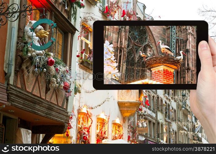 travel concept - tourist takes photo Christmas decoration in Strasbourg city, France on tablet pc