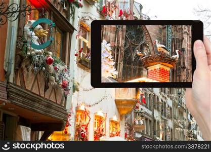travel concept - tourist takes photo Christmas decoration in Strasbourg city, France on tablet pc