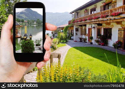 travel concept - tourist takes picture of Schliersee lake in Bavaria on smartphone, Germany