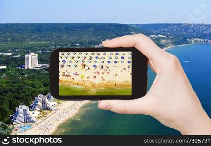 travel concept - tourist taking photo of Albena sand beach on mobile gadget, Bulgaria