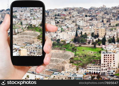 travel concept - tourist taking photo of Amman city on mobile gadget, Jordan