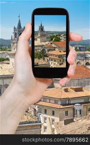 travel concept - tourist taking photo of Avignon city on mobile gadget, france