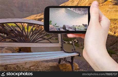 travel concept - tourist taking photo of Colorado River in Grand Canyon on mobile gadget, Nevada, USA