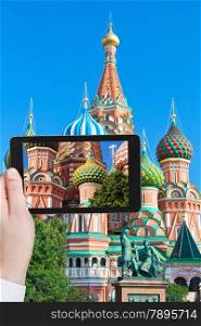 travel concept - tourist taking photo of colors towers of Saint Basil cathedral on Red Square in Moscow on mobile gadget, Russia