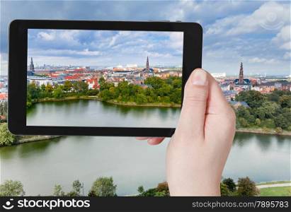 travel concept - tourist taking photo of Copenhagen center on mobile gadget, Denmark