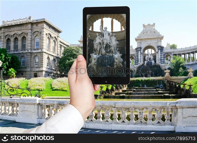 travel concept - tourist taking photo of fountain in Palais de Longchamp, Marseilles, France on mobile gadget