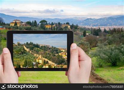 travel concept - tourist taking photo of green hills in Tuscany on mobile gadget, Florence, Italy