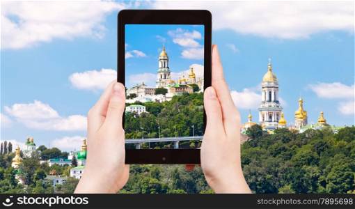 travel concept - tourist taking photo of Kiev Pechersk Lavra, Kiev, Ukraine on mobile gadget