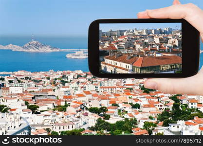 travel concept - tourist taking photo of Marseille city skyline on mobile gadget, France