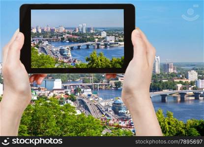 travel concept - tourist taking photo of modern Kiev skyline on mobile gadget