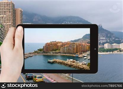 travel concept - tourist taking photo of Monaco city on mobile gadget