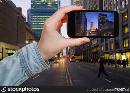 travel concept - tourist taking photo of New York City in evening on mobile gadget