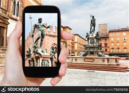 travel concept - tourist taking photo of Piazza Nettuno in Bologna on mobile gadget, Italy