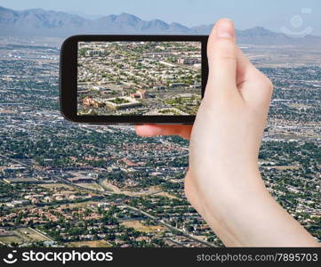 travel concept - tourist taking photo of residential area of Las Vegas on mobile gadget, USA