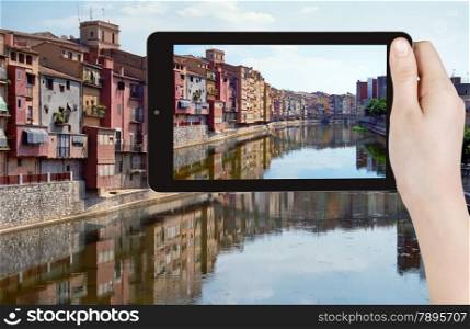 travel concept - tourist taking photo of river in Girona town on mobile gadget, Spain