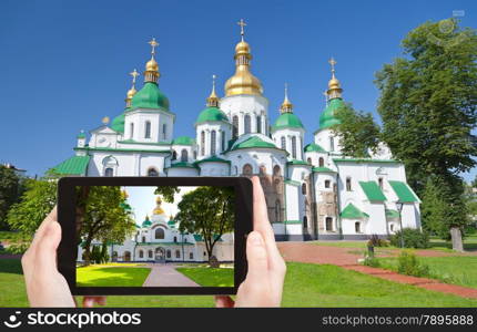 travel concept - tourist taking photo of Saint Sophia Cathedral in Kiev on mobile gadget, Ukraine