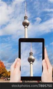 travel concept - tourist taking photo of TV tower on alexanderplatz on mobile gadget, Berlin, Germany