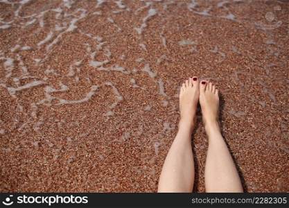 Travel concept - Woman&rsquo;s legs on beautiful tropical beach with pebble sand. Feet on sand and wave in summer time. girl barefoot in ocean water on vacation travel. Feel happy and relax. copy space. Travel concept - Woman&rsquo;s legs on beautiful tropical beach with pebble sand. Feet on sand and wave in summer time. girl barefoot in ocean water on vacation travel. Feel happy and relax. copy space.
