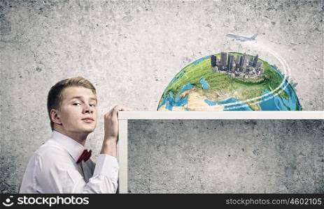 Travel concept. Young man pointing at modern city model. Elements of this image are furnished by NASA