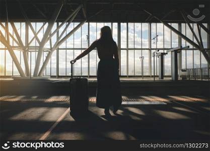 Travel Concept. Young Woman Waiting with Suitcase on the Platform at the Railway Station. Traveling by Train