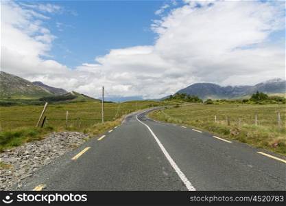travel, drive, landscape and countryside concept - asphalt road at connemara in ireland