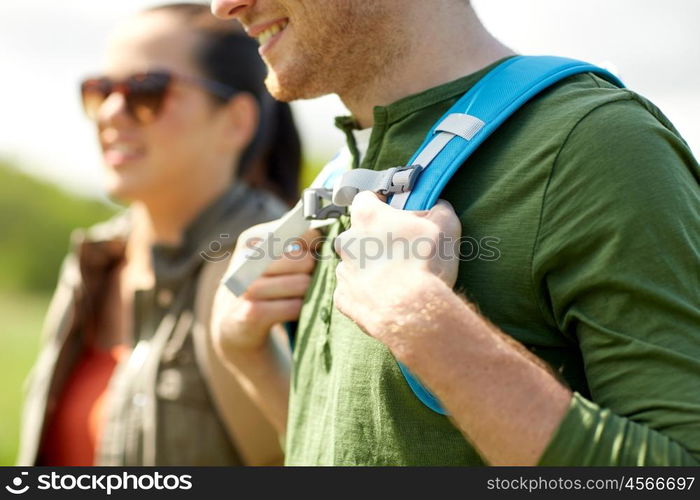 travel, hiking, backpacking, tourism and people concept - close up of couple with backpacks walking along country road