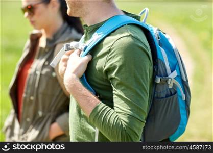 travel, hiking, backpacking, tourism and people concept - close up of couple with backpacks walking outdoors