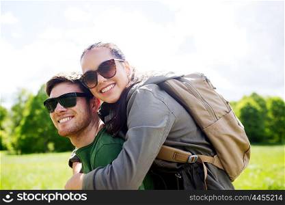 travel, hiking, backpacking, tourism and people concept - happy couple in sunglasses with backpacks having fun outdoors
