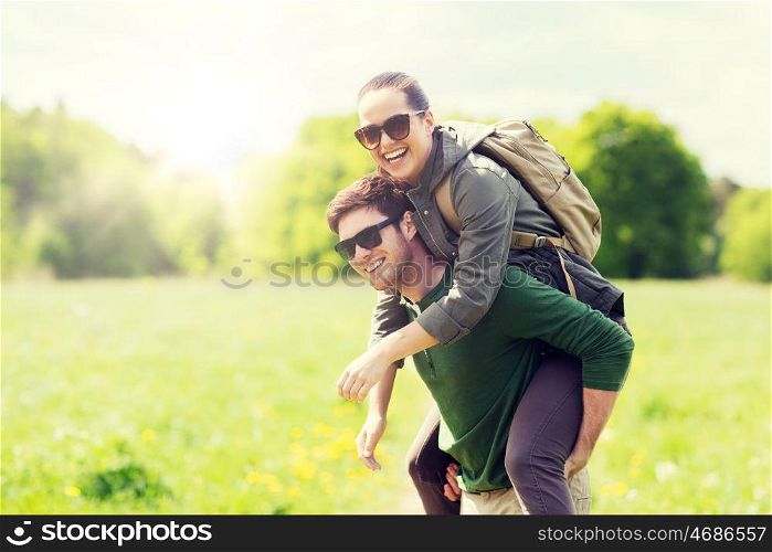 travel, hiking, backpacking, tourism and people concept - happy couple in sunglasses with backpacks having fun and walking along country road outdoors. happy couple with backpacks having fun outdoors. happy couple with backpacks having fun outdoors