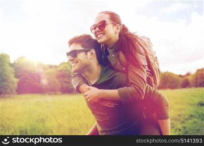 travel, hiking, backpacking, tourism and people concept - happy couple in sunglasses with backpacks having fun and walking along country road outdoors. happy couple with backpacks having fun outdoors