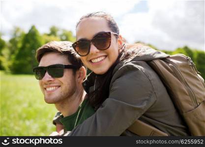 travel, hiking, backpacking, tourism and people concept - happy couple in sunglasses with backpacks having fun outdoors