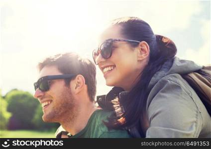 travel, hiking, backpacking, tourism and people concept - happy couple in sunglasses with backpacks having fun and hugging outdoors. happy couple with backpacks having fun outdoors. happy couple with backpacks having fun outdoors